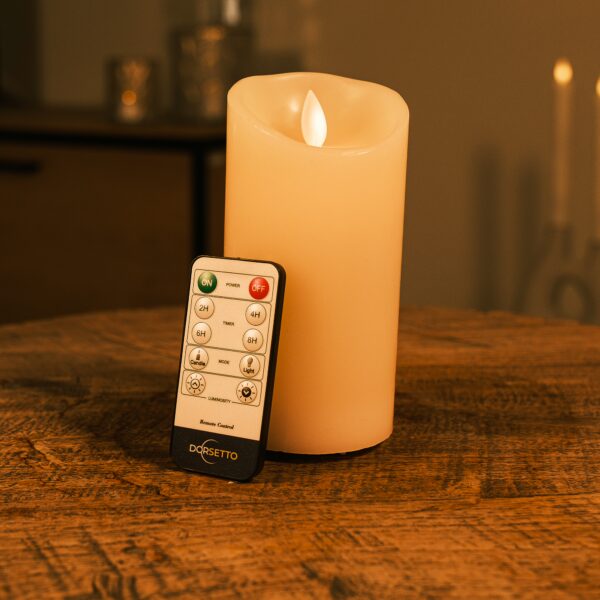 Home 24 Uppladdningsbart LED-vaxljus D 7,5 × 15 cm varmvit på träbord i stämningsfull miljö