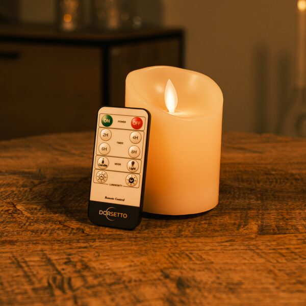 Uppladdningsbart LED-vaxljus med rörlig låga Ø 7,5 × 10 cm – varmvit – med fjärrkontroll på träbord
