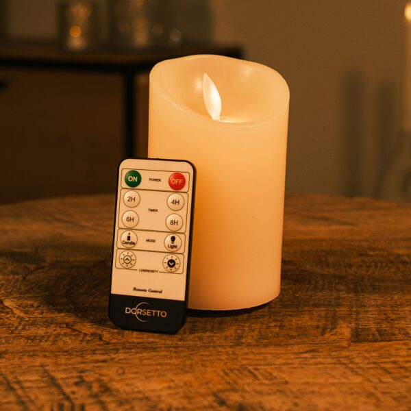 Uppladdningsbart LED-vaxljus med rörlig låga Ø 7,5 × 12,5 cm – varmvit – med fjärrkontroll på träyta