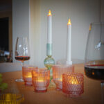 verschillende kaarsen van dorsetto op tafel bij groene druiven drogeworst en wijnglazen