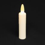 Uppladdningsbart LED-dinerljus DORSETTO 97 mm – löst, vitt ljus med glödande gul låga, stående mot enfärgad svart bakgrund.