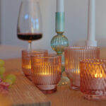 kaarsjes met een wijnglas en borrelplank op tafel