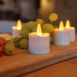 Uppladdningsbara vattentäta LED-värmeljus varmvit som skapar varm stämning på träbricka med snacks – inklusive fjärrkontroll