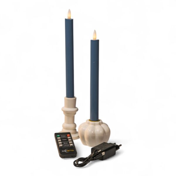 Två stenblå LED-dinerljus i vita ljushållare med fjärrkontroll och strömadapter på vit bakgrund, med realistiskt flameffekt.