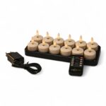 Ett set med 12 batteridrivna LED-värmeljus med realistiska lågor, placerade i en laddbricka. Även en svart nätadapter och en fjärrkontroll visas.
