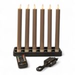 Sex stående mörkgrå uppladdningsbara LED-middagsljus (250 mm) på en svart bas, med dimbara lågor. Framför ligger en fjärrkontroll och en nätadapter för att styra setet med timer.